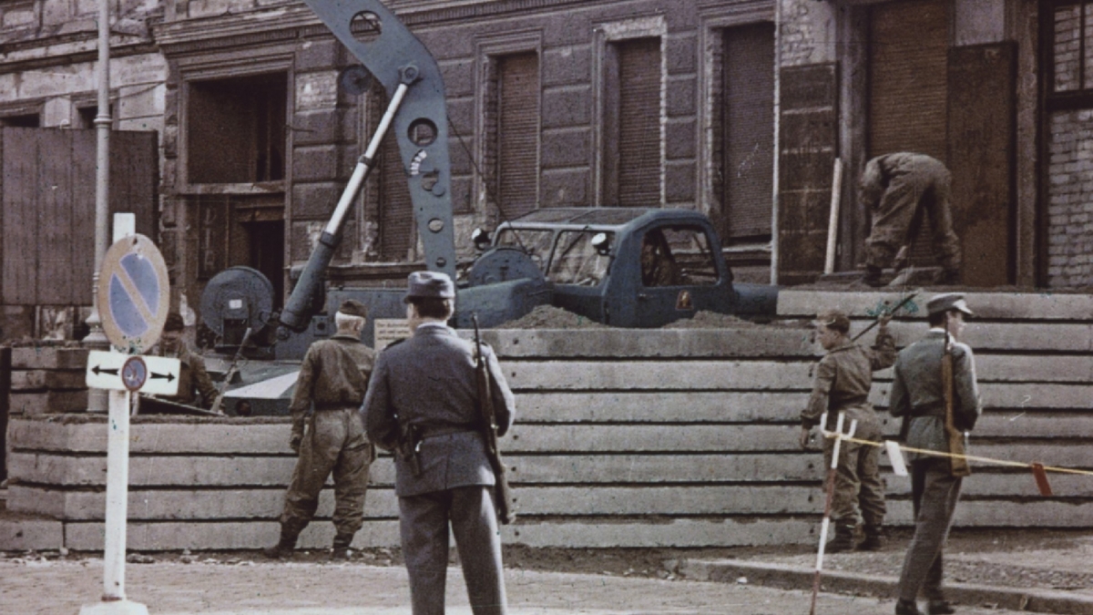 Bau der Mauer mit Soldaten und Fahrzeugen